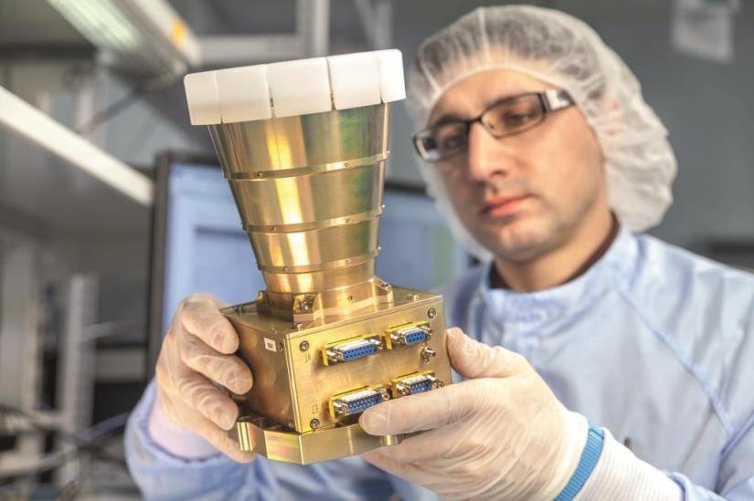 ein Kollege im Reinraum mit einem Sternsensor ASTRO APS in der Hand