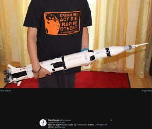 DRL_next #Projekt_4D zum Thema Spielzeug: Der Zwerg hat das TheMarsGeneration T-Shirt "Dream Big. Act Big. Instire Others." an und hält die LEGO-Saturn V in den Händen.