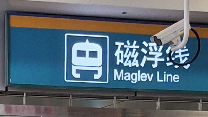 Hinweisschild im Flughafen zur Maglev Line mit stilisiertem Transrapid